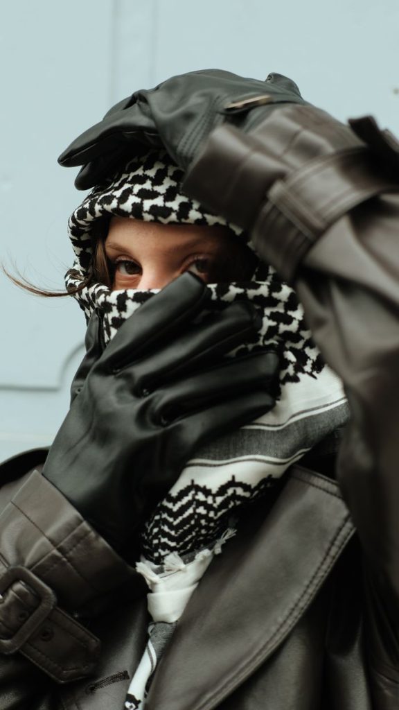 Close-up portrait of a fashionable woman in a coat and gloves, showcasing winter style.