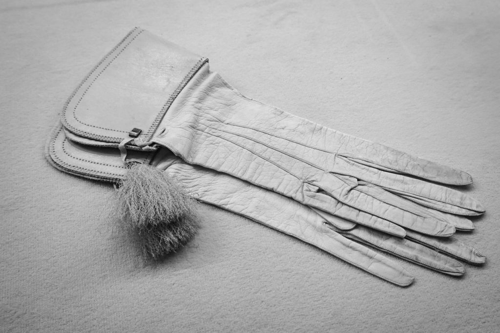 Elegant vintage leather gloves with tassel detail in a monochrome setting.